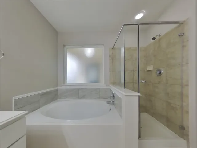 a white bath tub sitting next to a shower