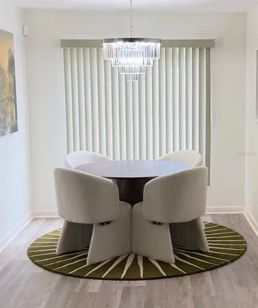 a living room with table chairs and a window