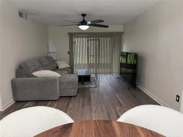 a living room with furniture and a wooden floor