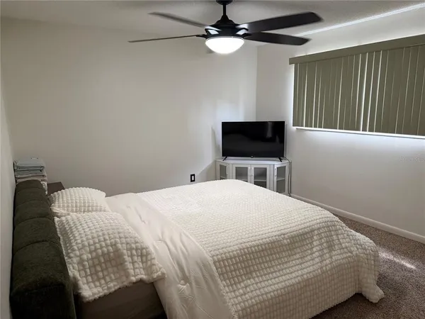 a bedroom with a bed tv and a chandelier