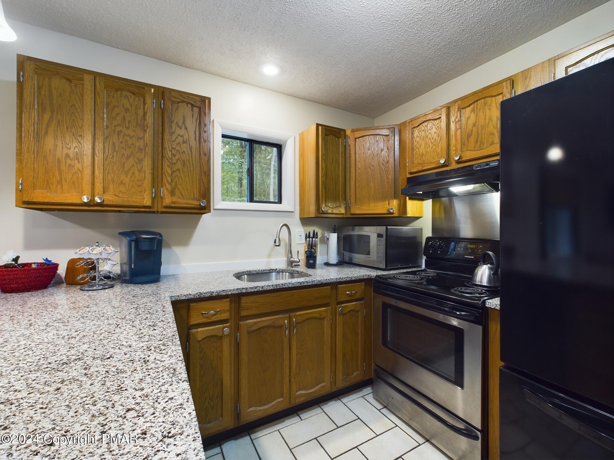 1245 Ranger Trail Pocono Lake, PA 18347 - Photo 12 of 59 a kitchen with stainless steel appliances granite countertop a sink stove and cabinets