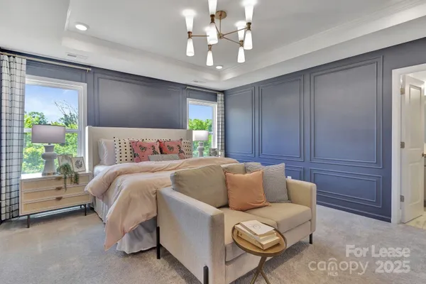 a bedroom with a bed and a chandelier