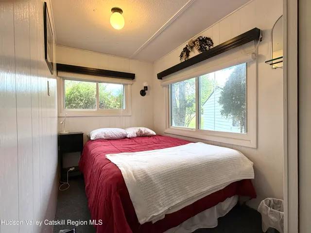 a bed sitting in a bedroom next to a window