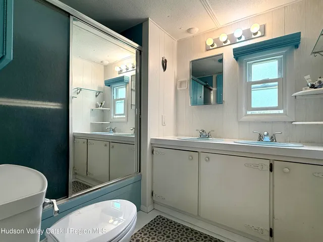 a bathroom with a toilet a sink a mirror and vanity