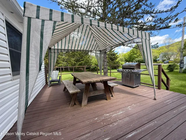 a view of a patio with table and chairs potted plants with wooden floor and floor to ceiling window
