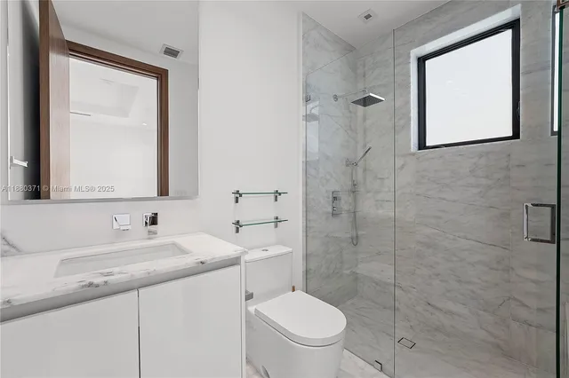 a bathroom with a toilet sink vanity and mirror