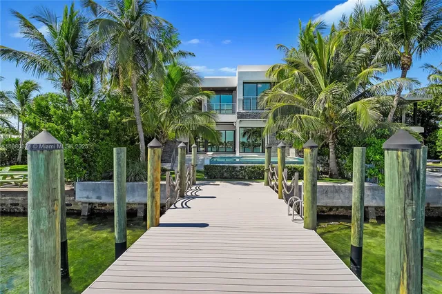 a view of a patio with table and chairs potted plants and palm trees