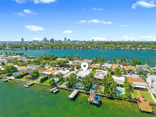 an aerial view of residential houses with outdoor space and lake view