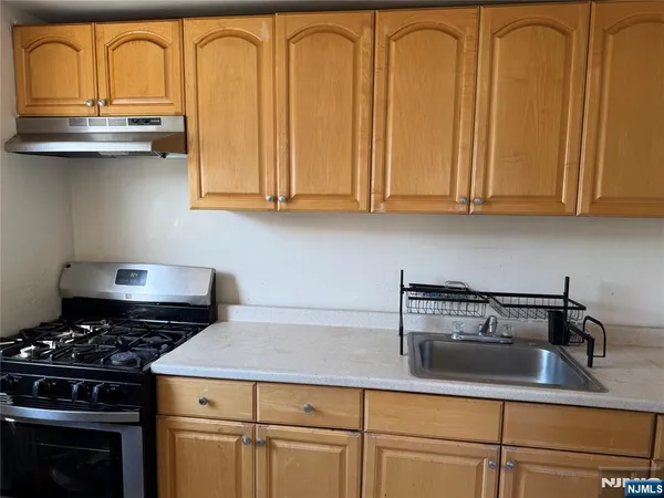 a kitchen with granite countertop a sink a stove and cabinets