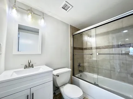 a bathroom with a sink a toilet and shower