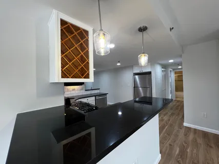 a kitchen with kitchen island a counter top space appliances and a ceiling fan