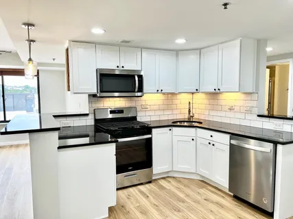 a kitchen with granite countertop a sink and steel appliances
