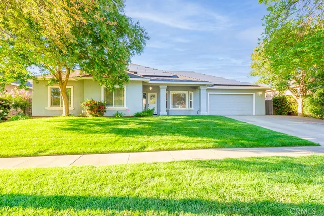 a front view of a house with a yard and trees