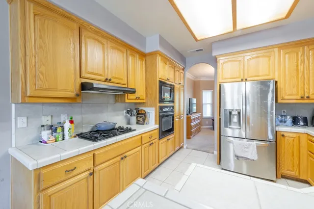 a kitchen with stainless steel appliances granite countertop a refrigerator a stove and a sink with cabinets