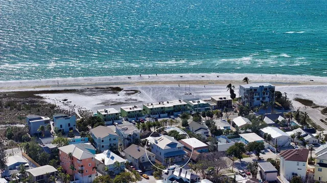 a living room with furniture two large window and a table