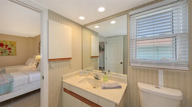 a bathroom with a granite countertop sink mirror and a toilet