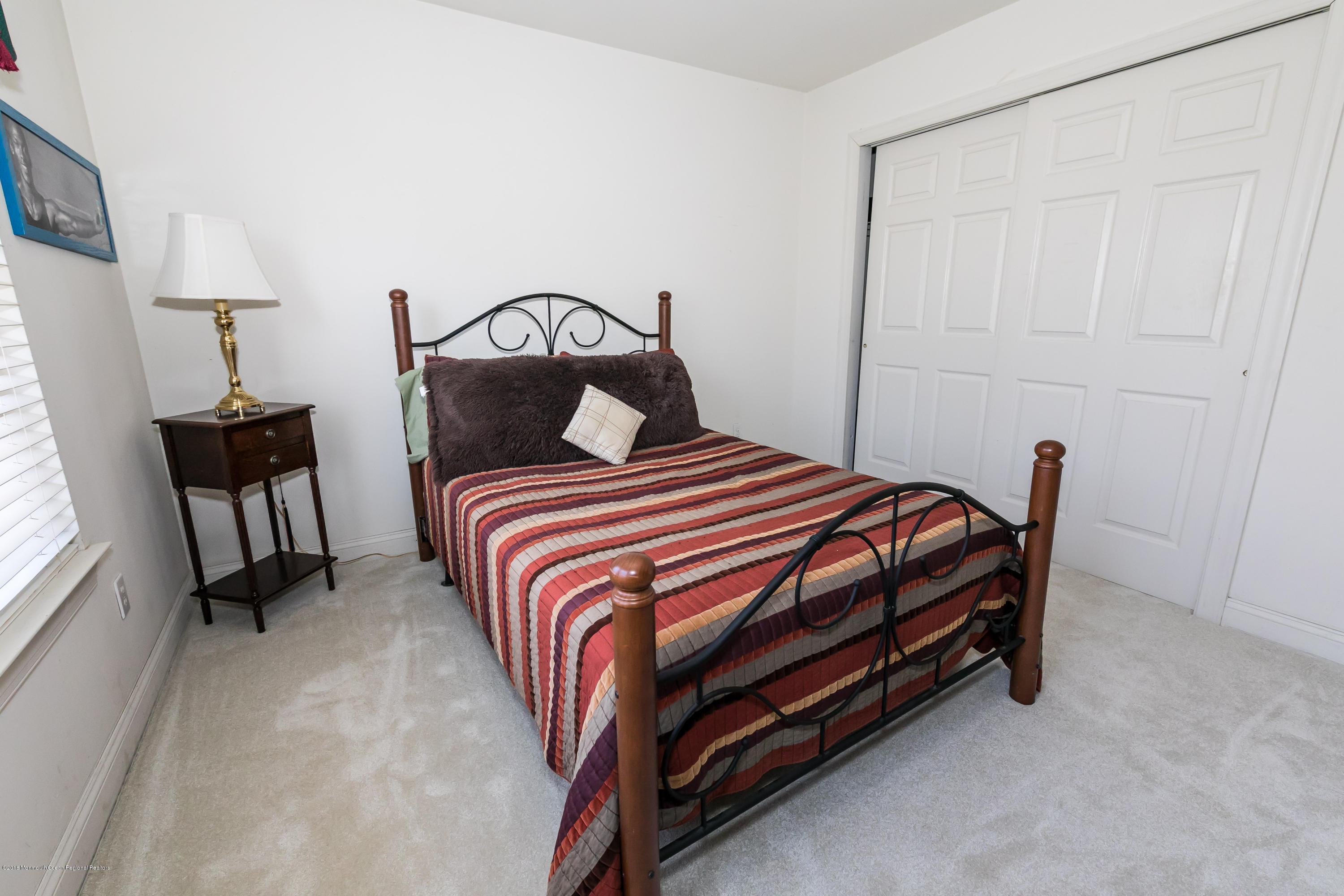 421 Diamond Road Jackson, NJ 08527 - Photo 16 of 24 a bedroom with a bed and a chandelier