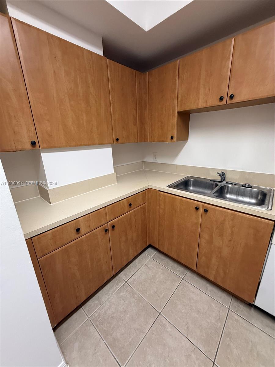 119 Southwest 6th Avenue, Unit 709 Miami, FL 33130 - Photo 3 of 18 a kitchen with cabinets a sink and a stove top oven