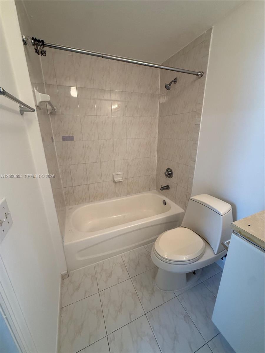 119 Southwest 6th Avenue, Unit 709 Miami, FL 33130 - Photo 5 of 18 a bathroom with a toilet and a bath tub