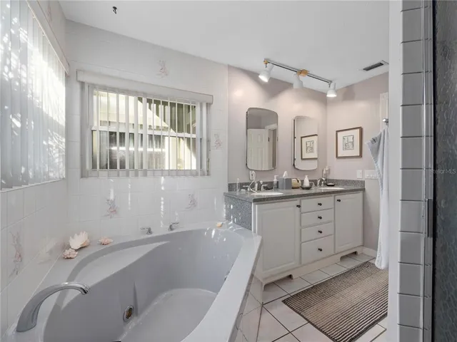 a bathroom with a granite countertop sink mirror bathtub and toilet