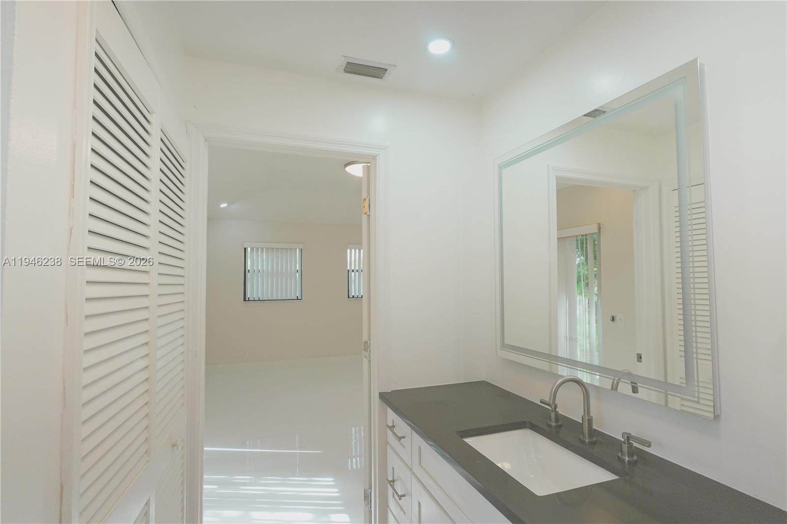 518 Northeast 48th Street, Unit 518 Boca Raton, FL 33431 - Photo 11 of 32 a bathroom with a sink and a mirror