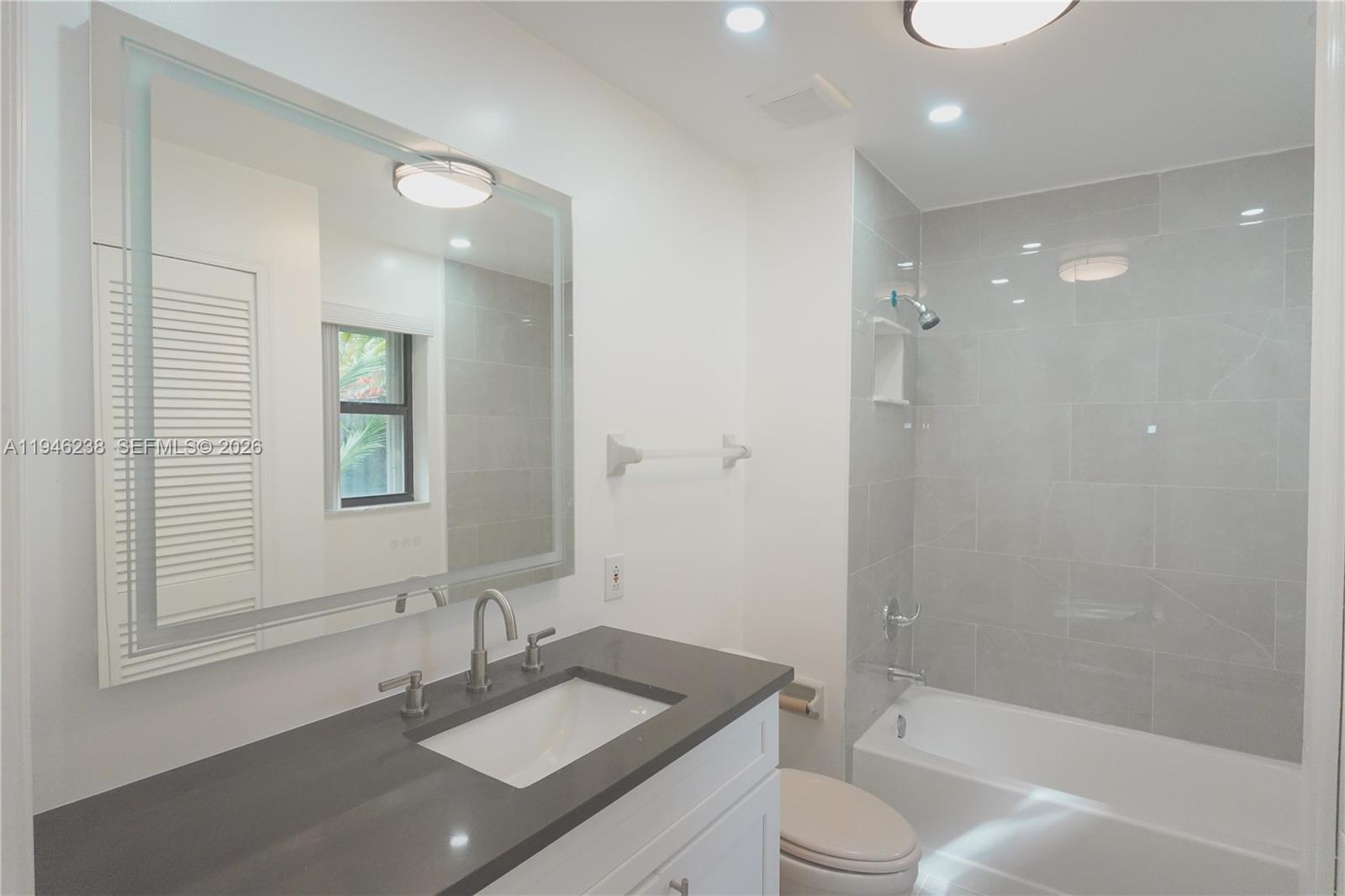 518 Northeast 48th Street, Unit 518 Boca Raton, FL 33431 - Photo 12 of 32 a bathroom with a granite countertop sink toilet and shower