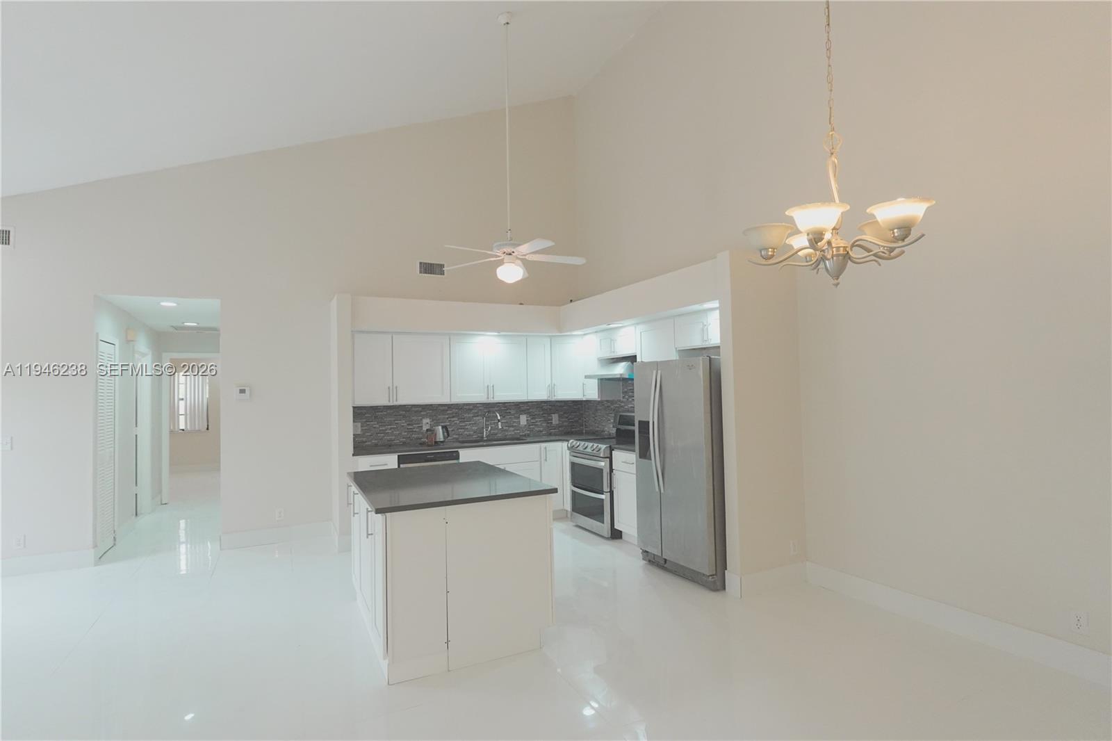 518 Northeast 48th Street, Unit 518 Boca Raton, FL 33431 - Photo 14 of 32 a view of a kitchen and a chandelier fan