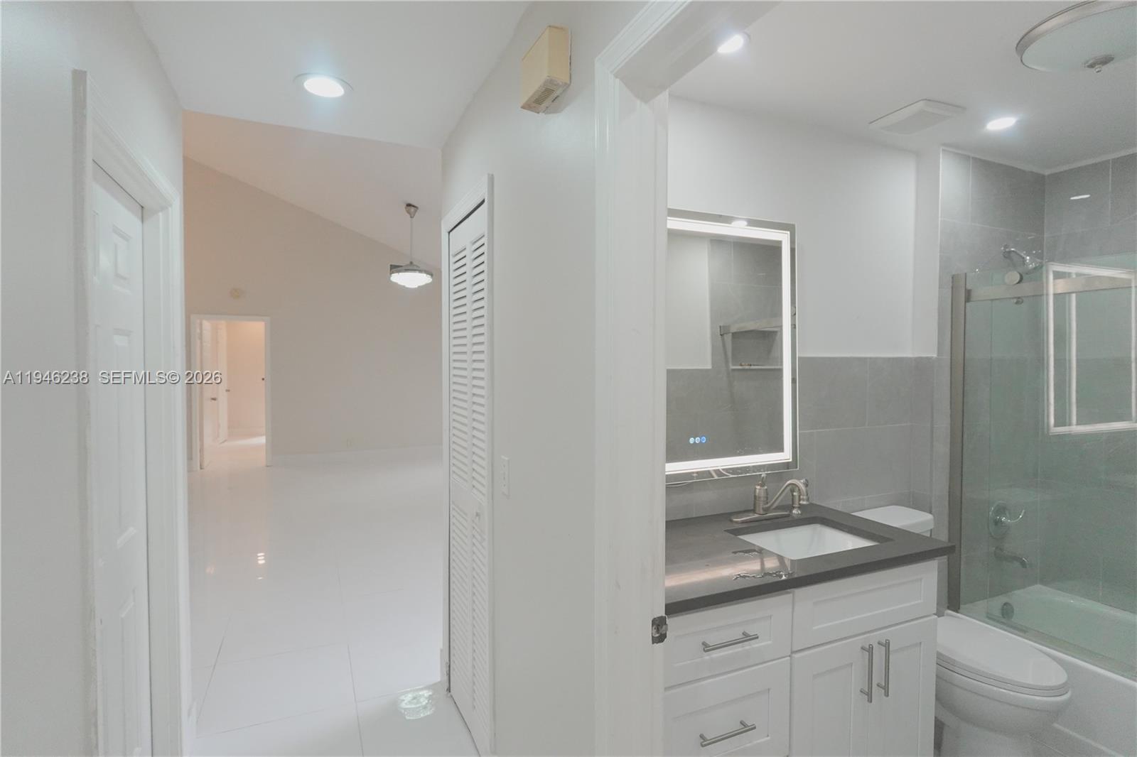 518 Northeast 48th Street, Unit 518 Boca Raton, FL 33431 - Photo 19 of 32 a bathroom with a granite countertop sink a toilet and shower