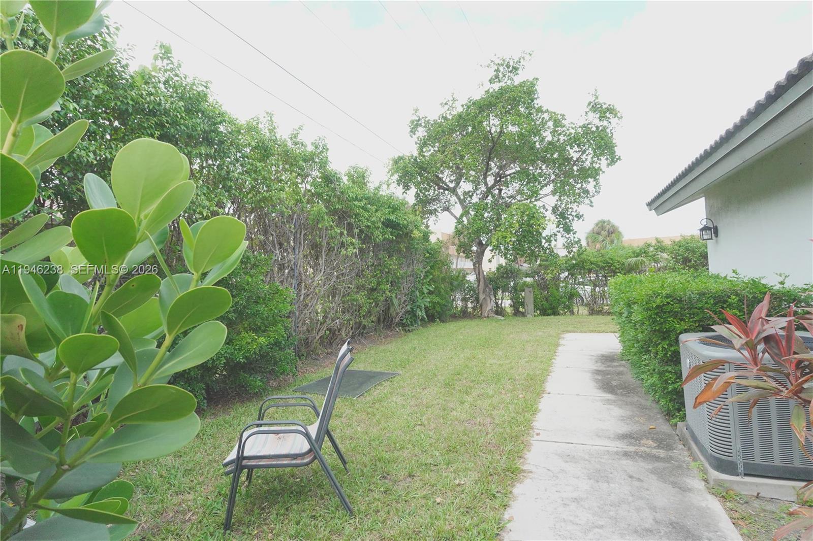518 Northeast 48th Street, Unit 518 Boca Raton, FL 33431 - Photo 24 of 32 a backyard of a house with table and chairs