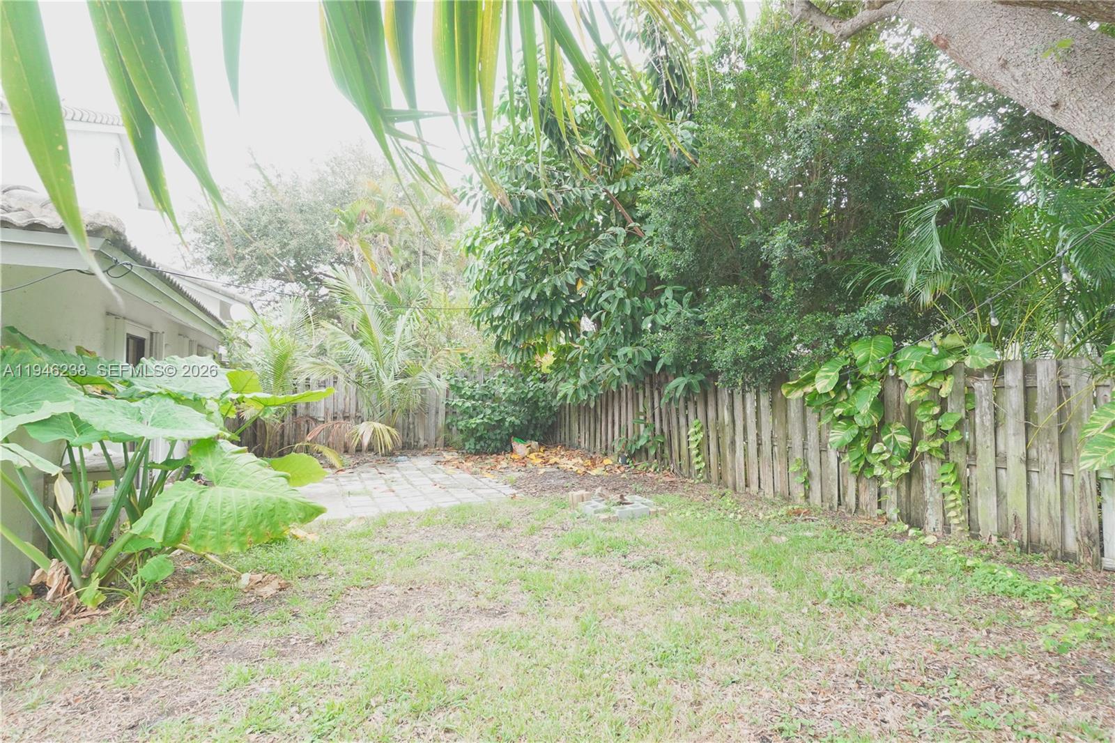 518 Northeast 48th Street, Unit 518 Boca Raton, FL 33431 - Photo 29 of 32 a backyard of a house with large trees and plants