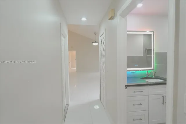 a bathroom with a granite countertop sink and mirror