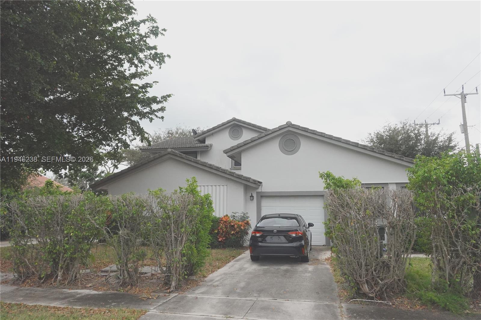 518 Northeast 48th Street, Unit 518 Boca Raton, FL 33431 - Photo 32 of 32 a car parked in front of white house