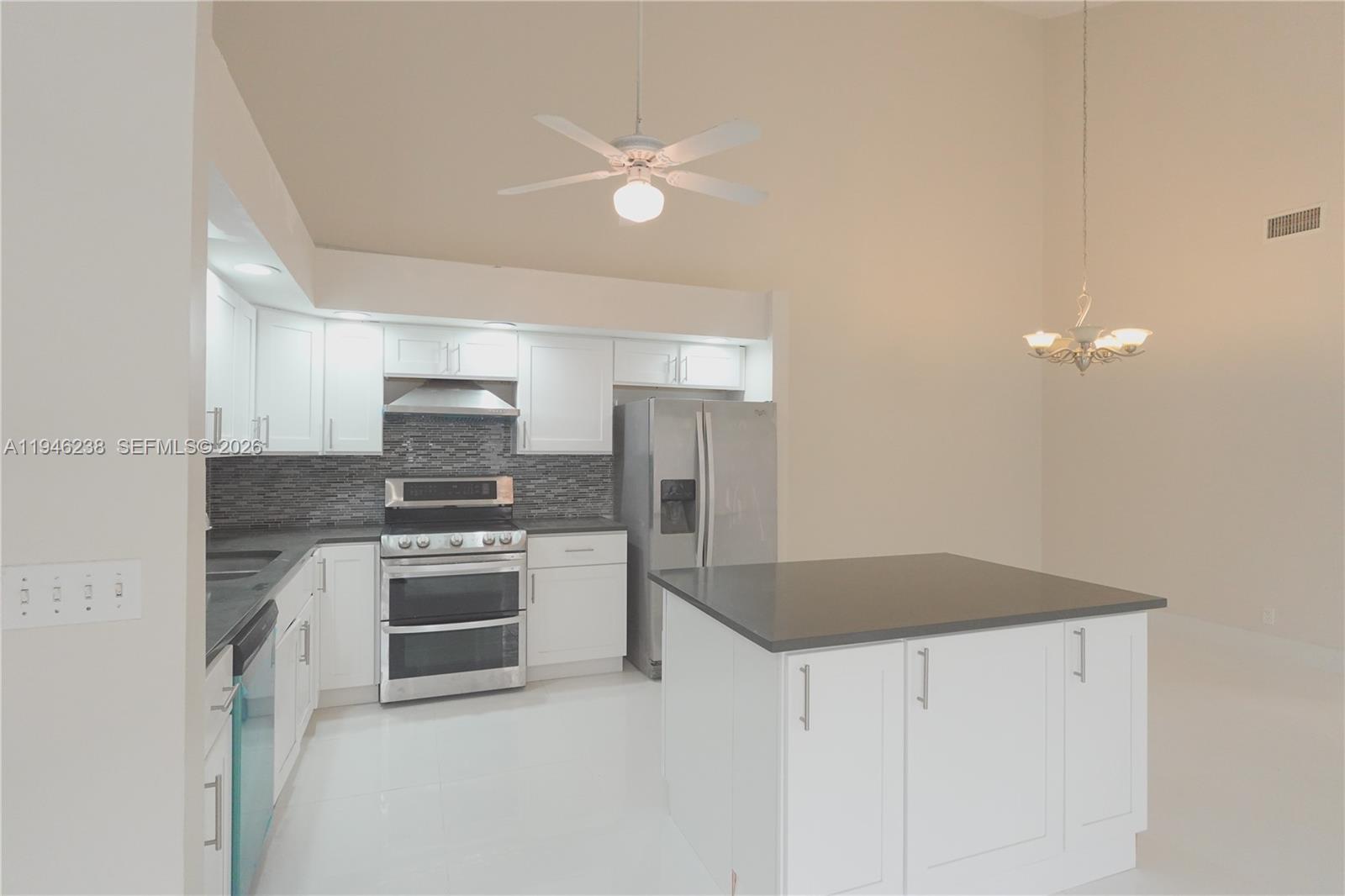 518 Northeast 48th Street, Unit 518 Boca Raton, FL 33431 - Photo 6 of 32 a kitchen with stainless steel appliances granite countertop a sink a stove a refrigerator with grey cabinets