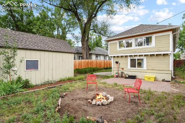 a backyard of a house with barbeque oven table and chairs