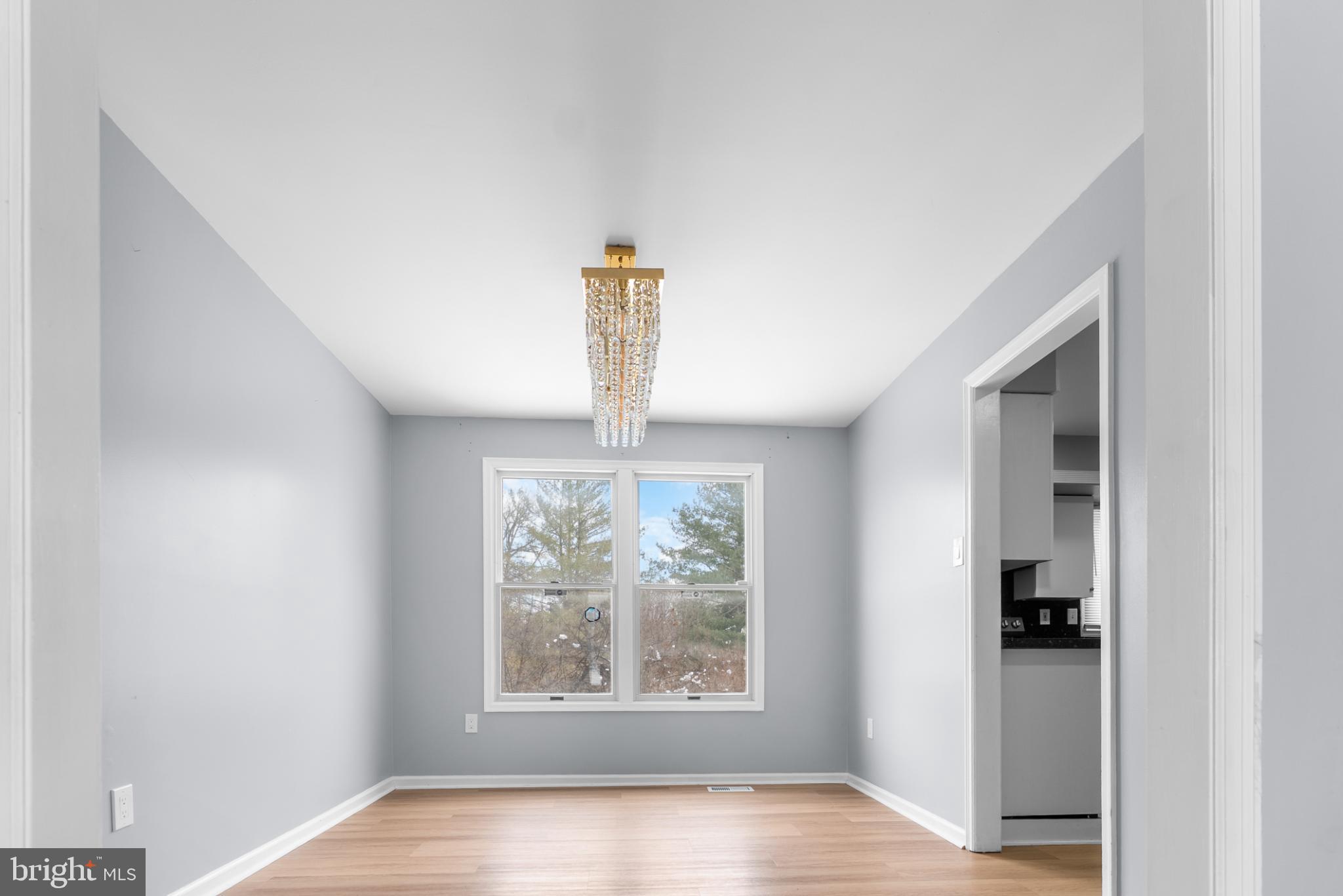 1137 Kingsbury Road Owings Mills, MD 21117 - Photo 7 of 24 a view of an empty room with wooden floor and a window