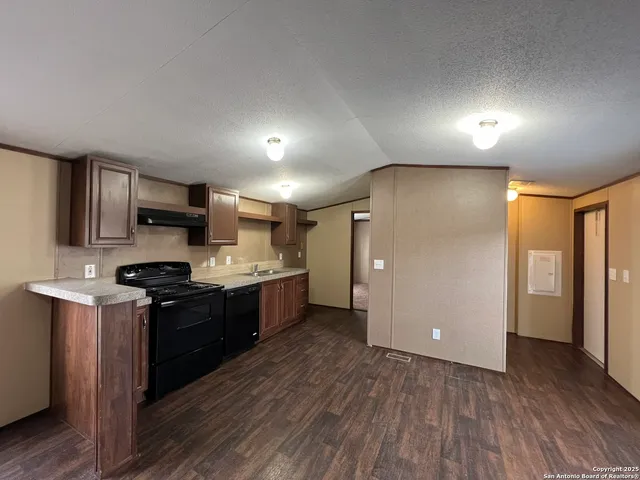 a kitchen with stainless steel appliances granite countertop a stove a refrigerator a sink dishwasher and a oven with wooden floor