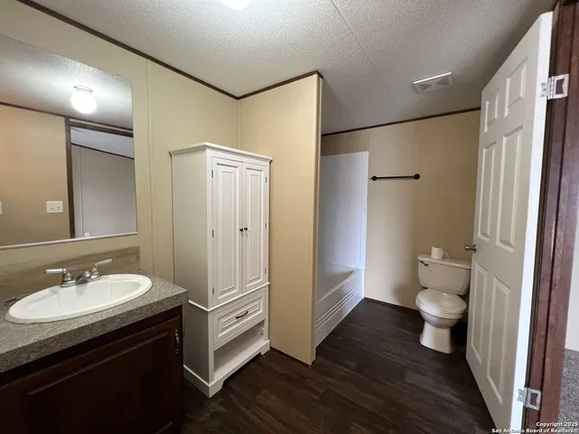 a bathroom with a sink a toilet a shower and a mirror