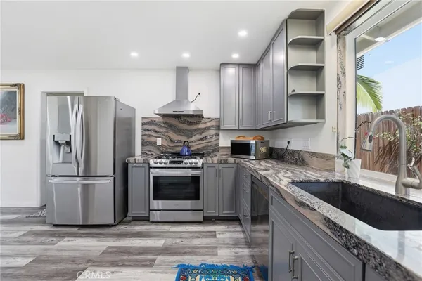 a kitchen with kitchen island granite countertop a sink cabinets and stainless steel appliances
