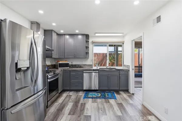 a kitchen with stainless steel appliances granite countertop a refrigerator and a stove