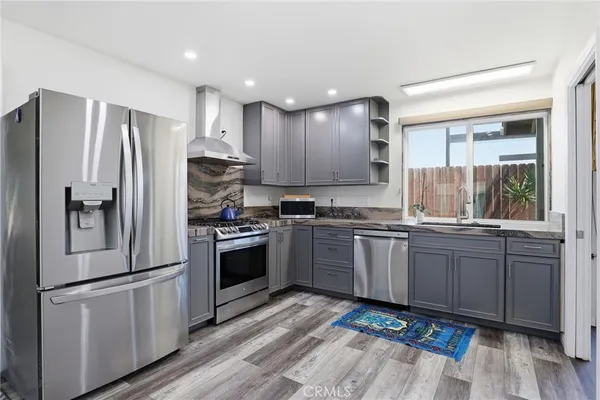 a kitchen with granite countertop stainless steel appliances and wooden cabinets
