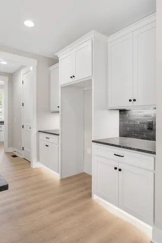 a kitchen with granite countertop white cabinets and white appliances