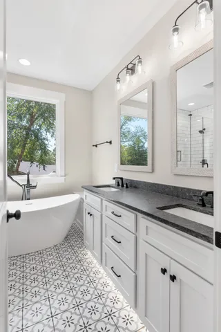 a bathroom with a granite countertop sink and a large mirror