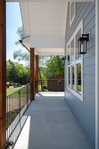 a view of a porch with wooden floor and iron stairs
