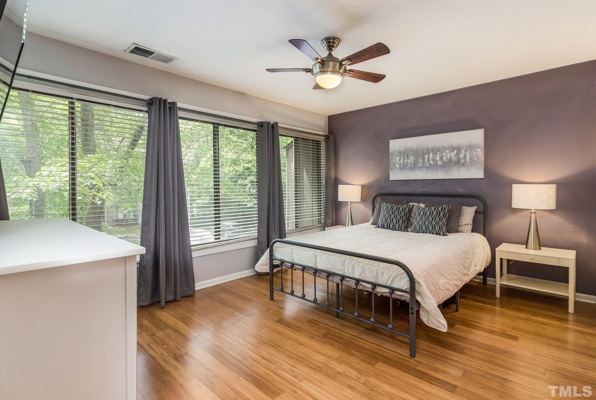1770 Quail Ridge Road Raleigh, NC 27609 - Photo 18 of 26 a bedroom with a large bed a chandelier and a large window
