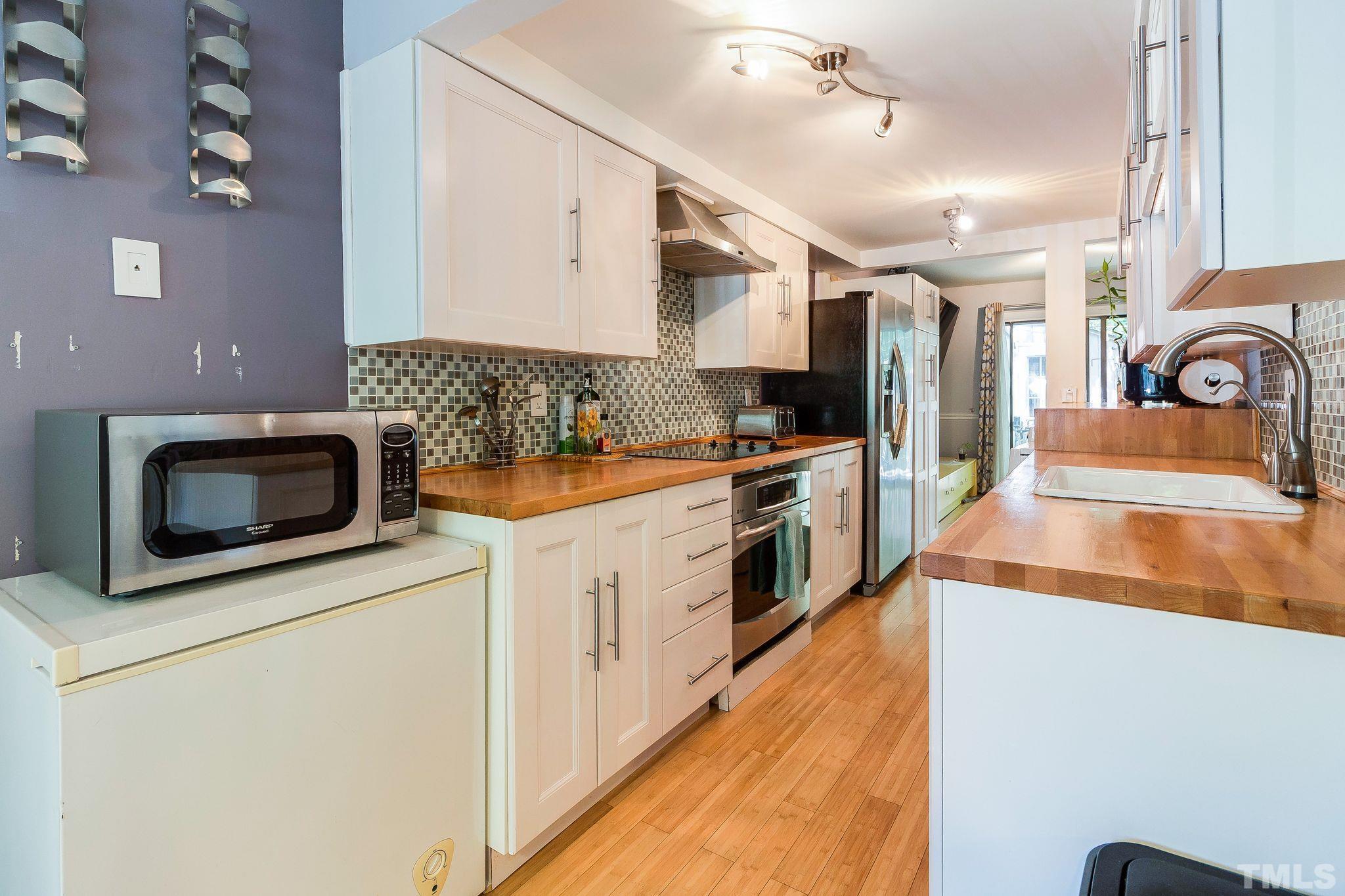 1770 Quail Ridge Road Raleigh, NC 27609 - Photo 9 of 26 a kitchen with stainless steel appliances kitchen island granite countertop a stove a sink and a microwave
