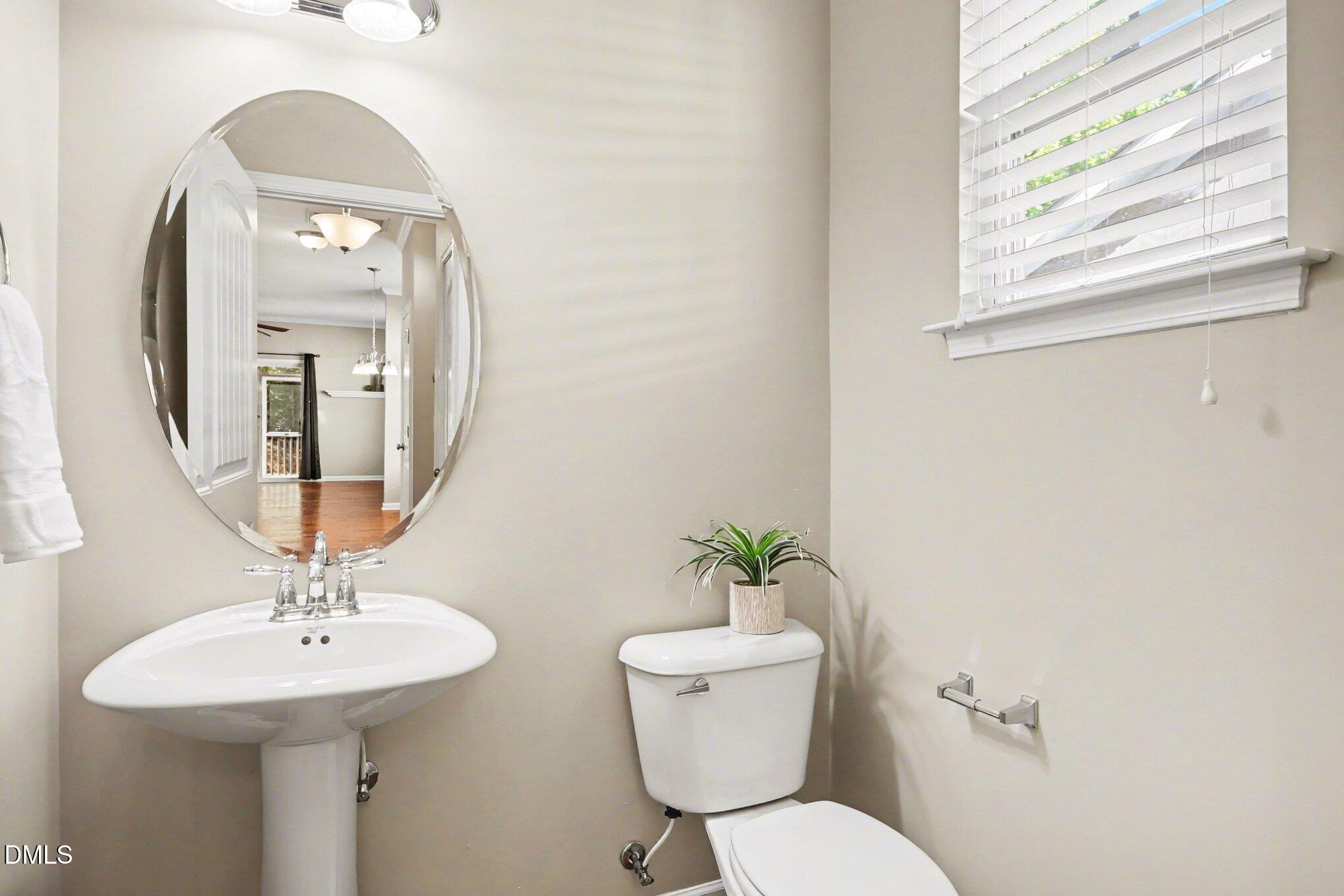 2409 Memory Ridge Drive Raleigh, NC 27606 - Photo 14 of 36 a bathroom with a toilet a sink and a mirror