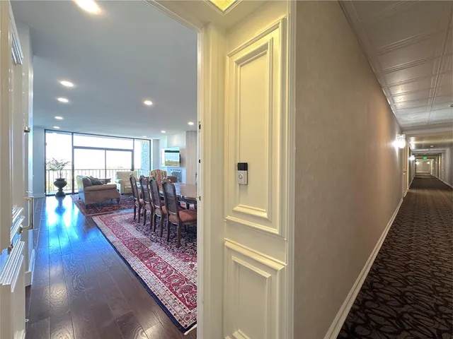 a view of a hallway with dining area and chandelier