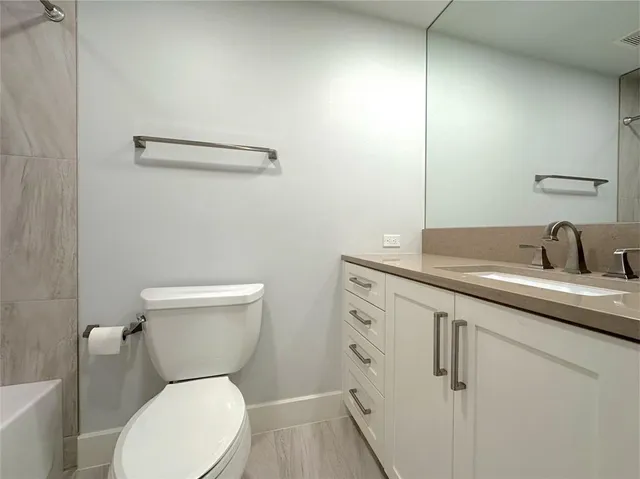 a white toilet sitting next to a bathroom sink