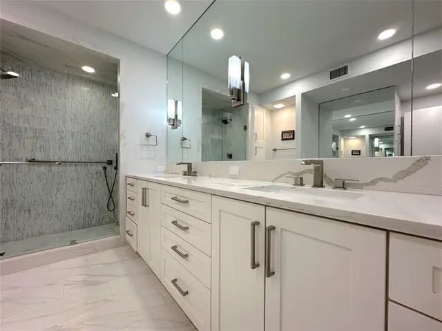 a bathroom with a double vanity sink mirror and shower