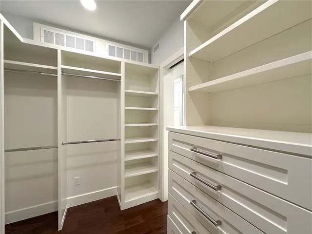 a view of walk in closet with empty racks
